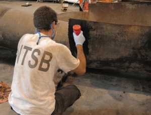 NTSB investigator examines welds on a pipeline section recovered from the San Bruno explosion.