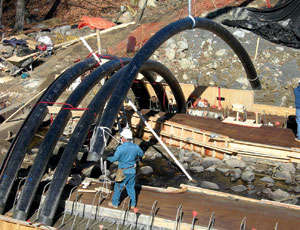 Acting as bridge arches for short spans, carbon tubes are inflated and filled with concrete by workers in Maine.