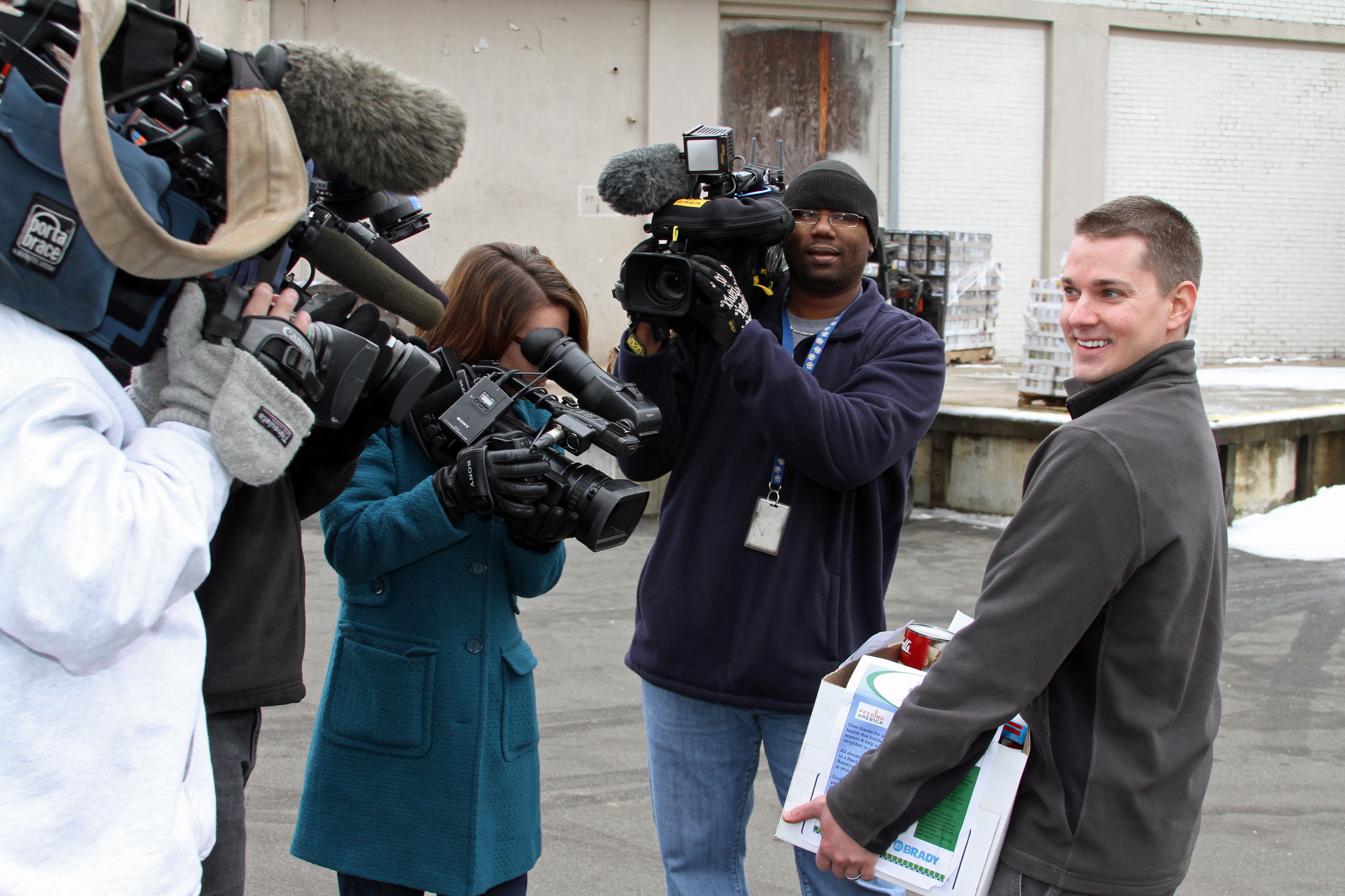 TV Crews Film Brady Associate Brady Adam Sippel Delivering Food to the Durham Food Bank