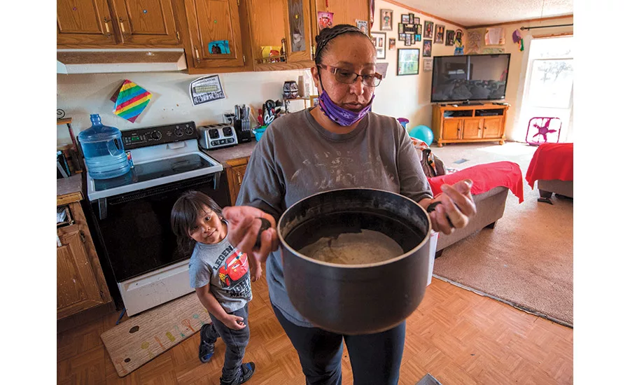 woman in the kitchen with a pot of water