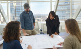 people around a table looking at building plans