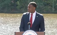Regan-PFAS.jpg EPA administrator stands at an outdoor podium with water flowing in the background