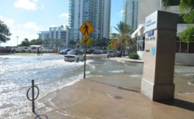 tidal flooding submerges a street in downtown Miami