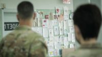 US Army personnel look at a wall of pictures colored by Afghan children at an evacuee processing facility near Philadelphia
