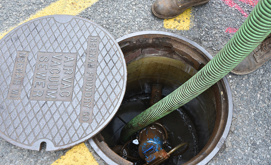 Dylan Kaeselau of James Roderick Septic pumps out a sewer hookup