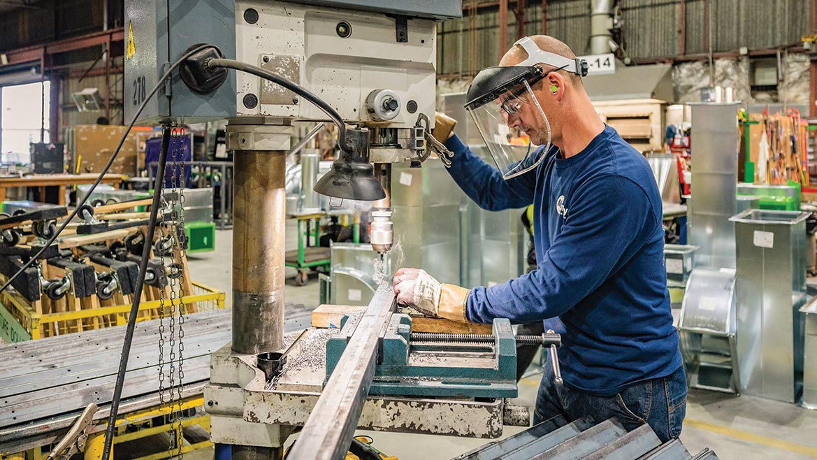 man operating a drill press