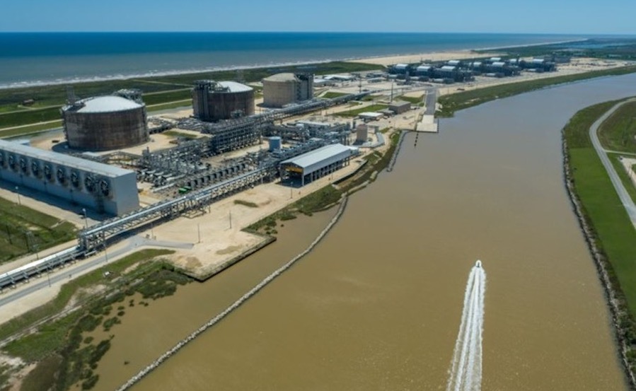 An LNG train is shown bordering a brown waterway