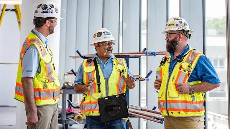 Construction workers talk on a project site