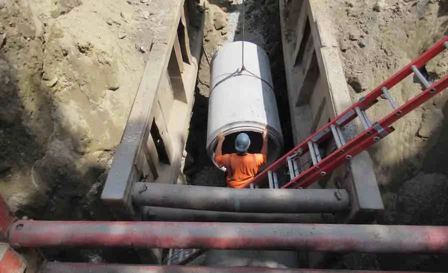 A worker sets a drain pipe 