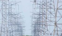 Two rows of transmission towers are shown against a blue sky