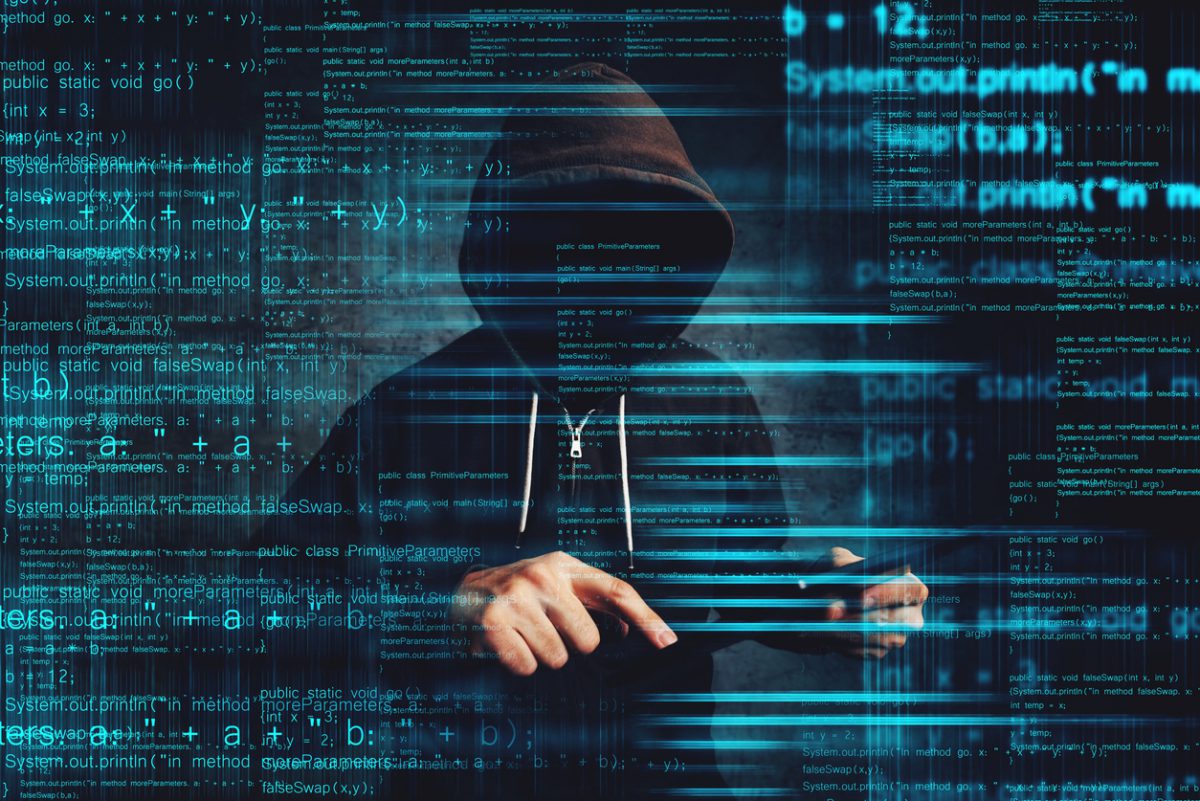 Person in black hoodie posing as a Cybersecurity Threat