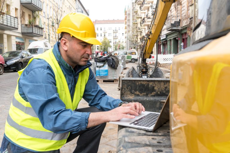Construction Worker Using Laptop in the Construction Field