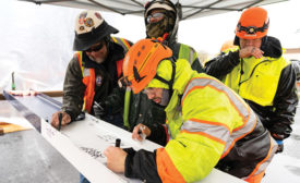construction workers signing a final beam