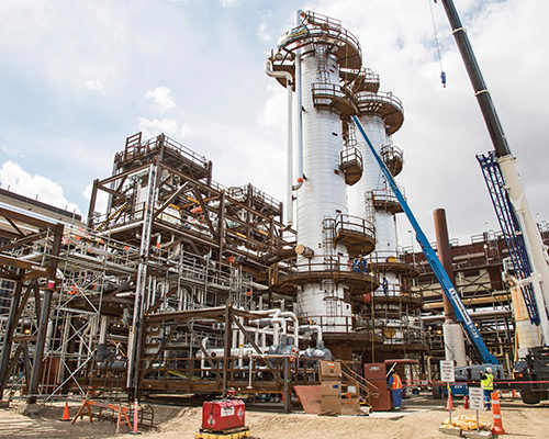 Image shows a carbon capture storage project with cranes and two white towers