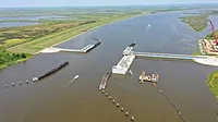 Houma Phase 2 Photo shows aerial view of lock construction on the water with land covered in green grass on either side