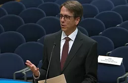 South Florida Water Management District Executive Director Drew Bartlett stands in front of a podium wearing a suit and tie