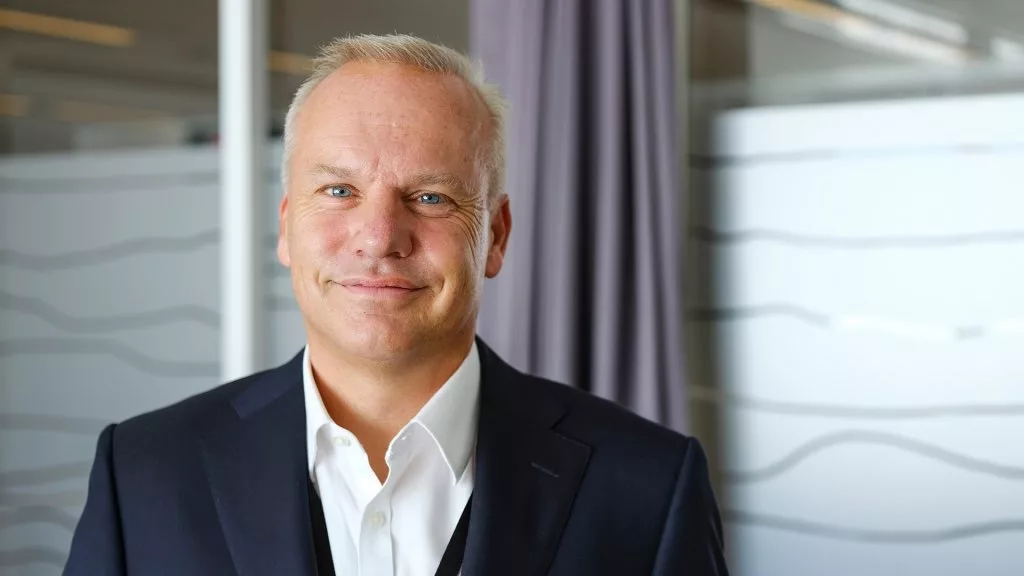 Headshot of Equinor CEO Anders Opedal, smiling and wearing a white button-down and blacks suit