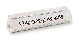 Image of a rolled up newspaper with Quarterly Results writing in black letters, underlined in red. 
