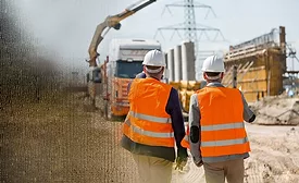 construction site and two men in orange vests