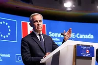 Mark Carney, Canada PM Canada Prime Minister Mark Carney stands at a podium wearing a blue suit