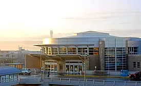 Boise Airport terminal exterior in morning light, highlighting the modern glass entry. Expansion aims to add gates and infrastructure to handle record passenger growth.
