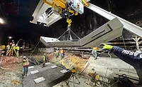 Crews position a precast concrete tunnel invert segment inside the Howard Street Tunnel