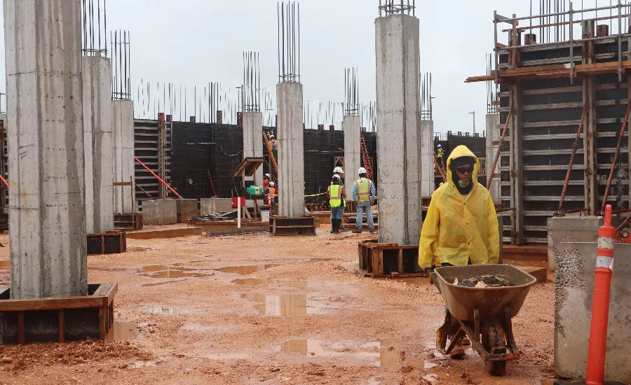 Construciton crews work on a military construction project in Guam on a rainy day