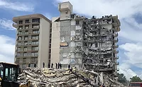 Champlain-Towers---New-Report Surfside condo collapse scene showing debris and responders; NIST says failure began in pool deck slab-column connection.