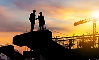 ABC-August-2025---Construction-Backlog-Report Silhouette of two construction professionals on a jobsite at sunset with cranes in the background, illustrating ABC’s August 2025 report showing backlog at 8.5 months and contractor optimism holding steady.