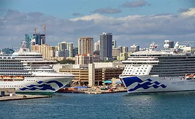 Two cruise ships docked at Port Everglades with Fort Lauderdale skyline in the background, where a $152.2-million bulkhead replacement project is underway