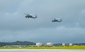 Two MH-60S SeaHawk helicopters are seen flying over Andersen Air Force Base