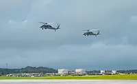 Two MH-60S SeaHawk helicopters are seen flying over Andersen Air Force Base