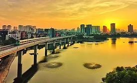 Elevated Hanoi Metro train crossing Hoang Cau Lake at sunset.