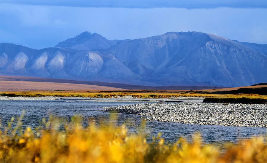 The Canning River flows through the Arctic National Wildlife Refuge, with mountains visible in the distance