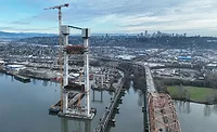 Aerial view of new Pattullo Bridge tower under construction beside existing bridge over the Fraser River in British Columbia.