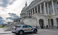 United States Capitol with a Capitol Police vehicle parked outside on the day the Senate advanced a deal to end the 41-day shutdown.