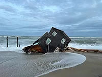 house falling into ocean