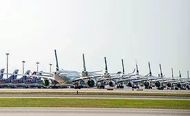 Line of commercial aircraft parked on an airport apron.
