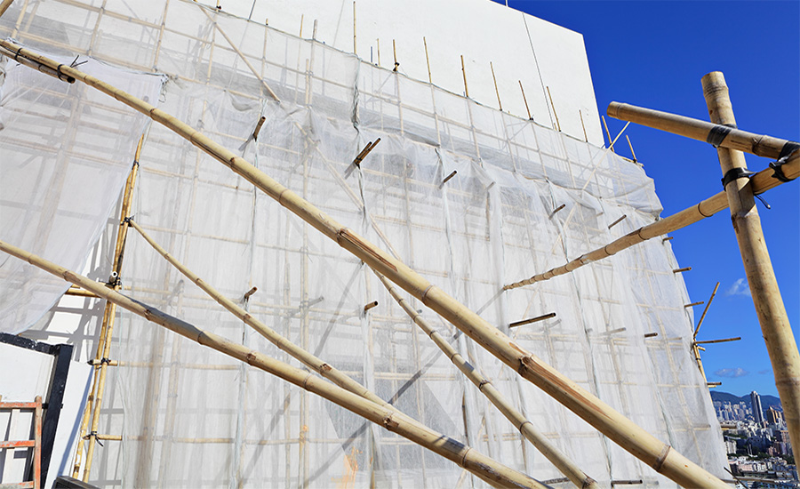 Bamboo scaffolding and mesh on a Hong Kong high-rise facade.