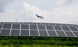 Photo shows an airplane flying over a solar array at the Pittsburgh International Airport