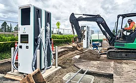Construction crews install public electric vehicle charging equipment.
