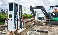 Construction crews install public electric vehicle charging equipment.
