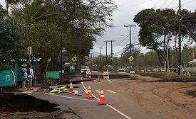 People look over a road damaged by a kona storm on Sunday, March 15, 2026, in Maui County, Hawaii.