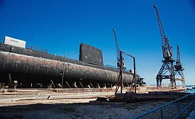 Submarine under construction with cranes and industrial infrastructure