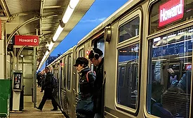 CTA train at Howard station in Chicago with riders boarding on platform