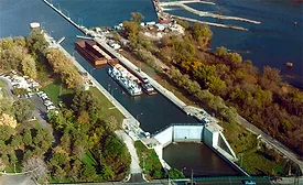 Aerial view of Brandon Road Lock and Dam in Joliet, Illinois, with barge traffic in the channel.
