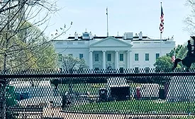 White House seen from Lafayette Square with fencing and visible construction activity on the grounds in Washington, D.C.