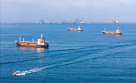 Oil tankers waiting offshore near port cranes