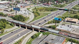 Aerial view of freight train crossing a bridge over a busy Chicago highway corridor
