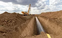 Keystone-Light Pipeline installation in an open trench with heavy equipment on site.